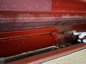 旭川市 外壁塗装工事で車庫の鉄部に赤い錆止めを塗装している工程