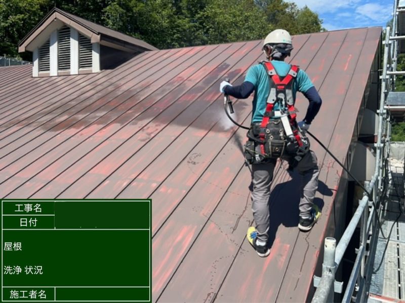 建物 屋根塗装 高圧洗浄の様子 安全帯着用で急勾配屋根を洗浄