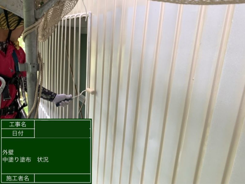 建物 外壁塗装 中塗り施工中 ローラーで均一に塗布